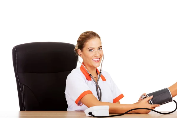 Glimlach vrouwelijke arts of verpleegkundige controleren van de bloeddruk patiënt — Stockfoto