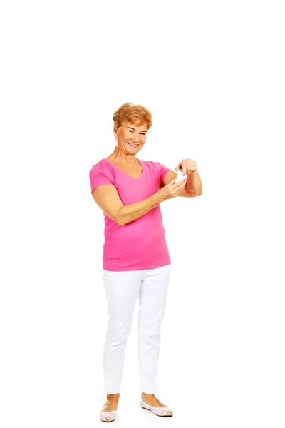 Smiling senior woman holding jar of pills — Stock Photo, Image