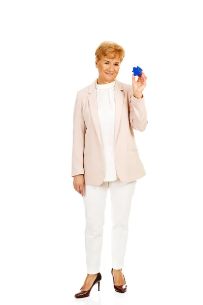 Glimlach oudere vrouw met blauwe sleutel hanger — Stockfoto
