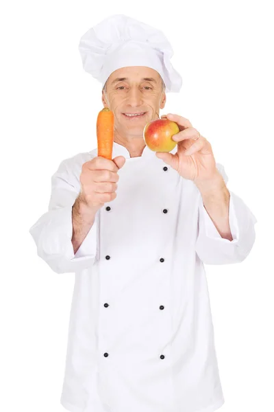 Männlicher Koch mit Apfel und Karotte — Stockfoto