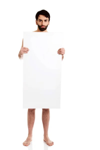 Un joven sin camisa sosteniendo una pancarta vacía . — Foto de Stock