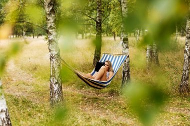 Hamakta tabletli genç bir kadın