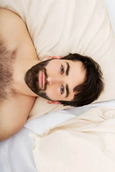 年轻肌肉男躺在床上. — 图库照片