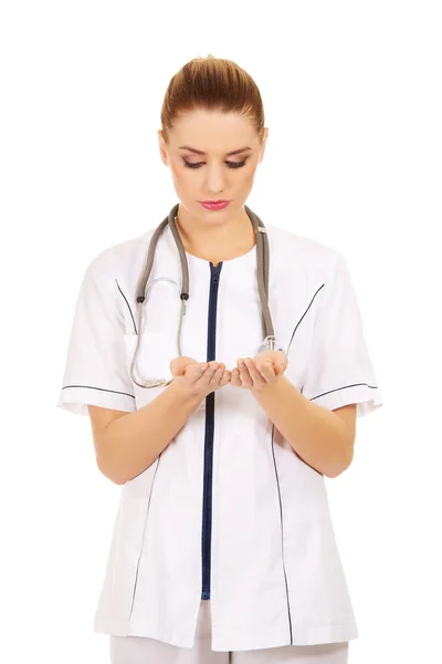 Ženský lékař něco drží otevřené dlaně — Stock fotografie