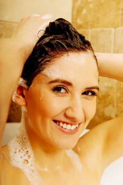 Joven mujer feliz lavando el cabello en el baño —  Fotos de Stock