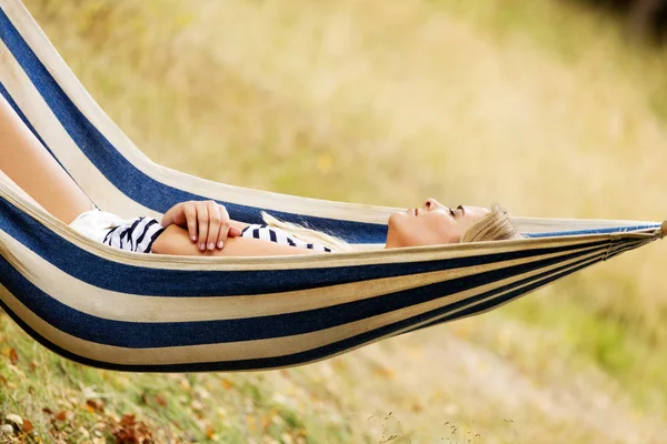 Mujer rubia joven descansando en la hamaca — Foto de Stock