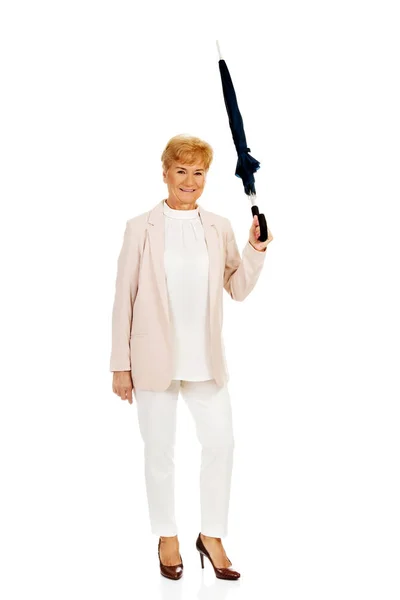 Mulher de negócios idosos feliz apontando para cima com guarda-chuva — Fotografia de Stock