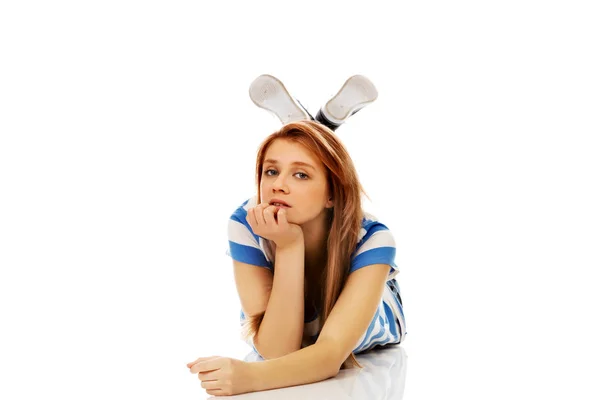 Pensive teenage woman lying on the floor — Stock Photo, Image