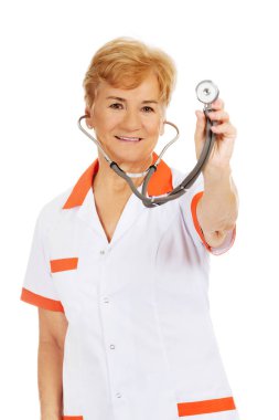 Yaşlı kadın doktor stetoskop tutarak gülümseyin