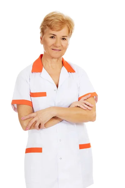 Lächeln ältere Ärztin oder Krankenschwester mit verschränkten Armen — Stockfoto