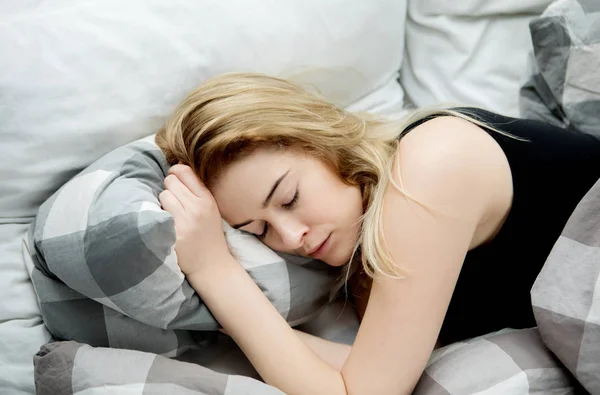 Mujer joven durmiendo en su cama . —  Fotos de Stock