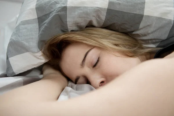 Mladá žena spí v posteli. — Stock fotografie