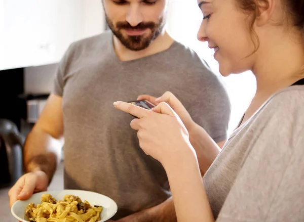 Pareja tomando fotos de espaguetis con teléfono inteligente — Foto de Stock