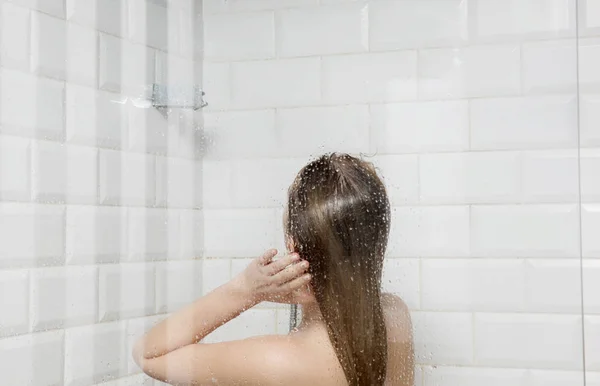 Belle jeune femme nue prenant douche dans la salle de bain — Photo