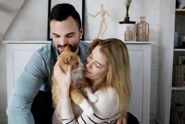 Happy couple with cat at home — Stock Photo, Image