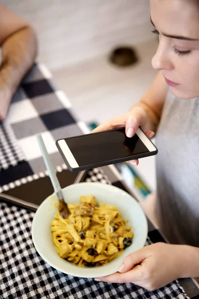 Woman taking photo of spaghetti with smart phone — Stock Photo, Image