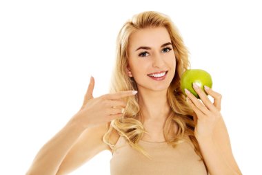 Genç mutlu kadın taze yeşil elma yiyor.