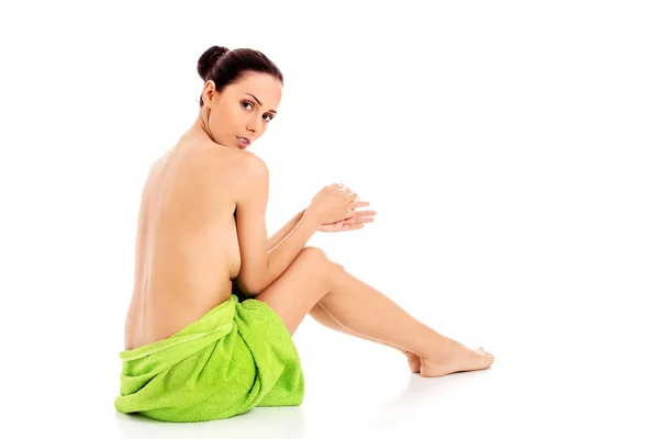 Mulher usando toalha sentada no chão, vista traseira. — Fotografia de Stock