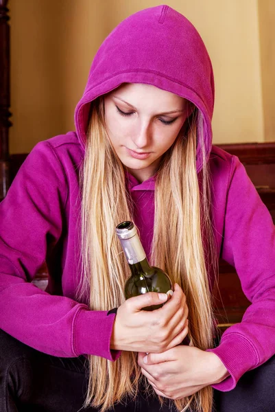 Dronken jonge vrouw met fles alcohol — Stockfoto