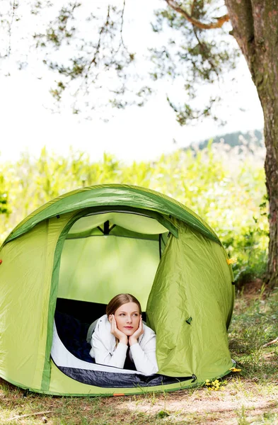 Молодая женщина отдыхает в палатке на природе — стоковое фото