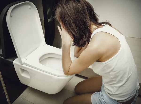 Woman vomiting in toilet. — Stock Photo, Image