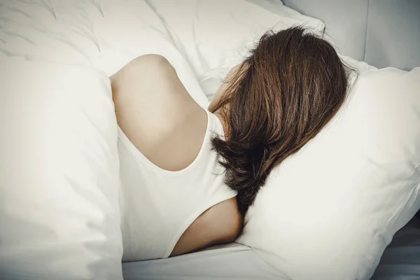 Γυναίκα ξαπλωμένη στο κρεβάτι της, στο σπίτι. — Φωτογραφία Αρχείου