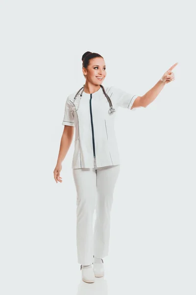 Full length medico femminile che indica la destra — Foto Stock