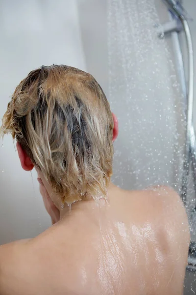 Beautiful naked woman washing her hair while taking shower. — Stockfoto