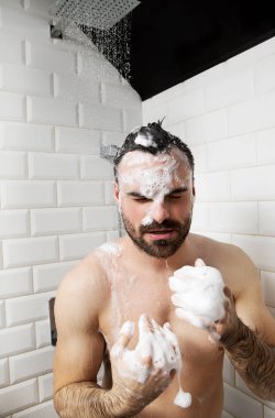 Çıplak yakışıklı genç alarak duş banyoda