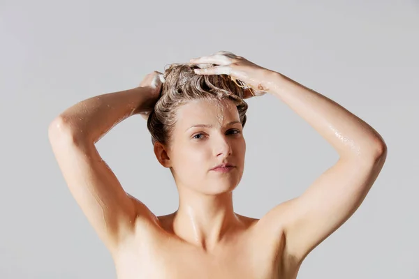 Kobieta, mycie jej blond włosy — Zdjęcie stockowe