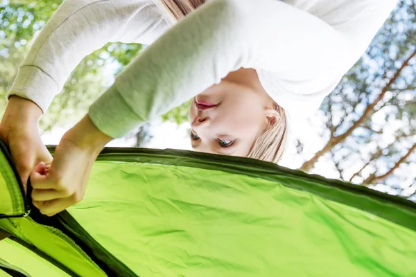 Молодая блондинка ставит палатку. — стоковое фото
