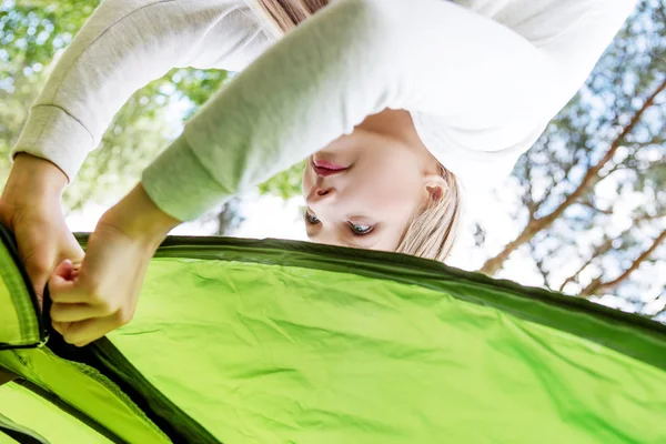 Jong blond vrouw pitching een tent. — Stockfoto