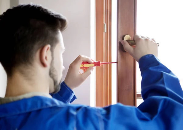 Молодой мастер ремонта окна с отверткой — стоковое фото