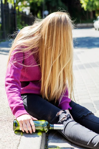 Dronken jonge vrouw met fles alcohol — Stockfoto