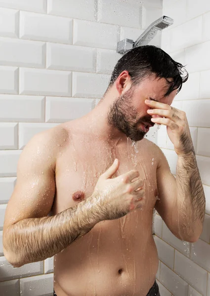 Schöner nackter junger Mann unter der Dusche im Badezimmer — Stockfoto