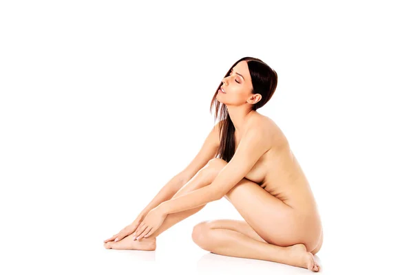 Giovane donna nuda seduta sul pavimento — Foto Stock