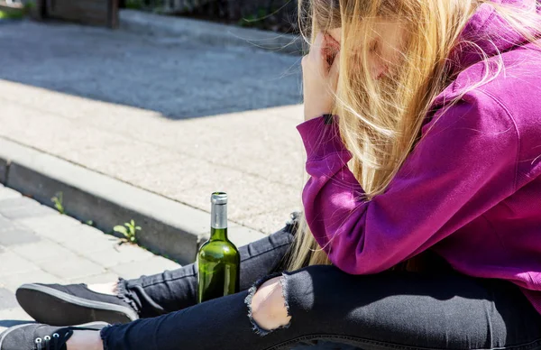 Dronken jonge vrouw met fles alcohol — Stockfoto