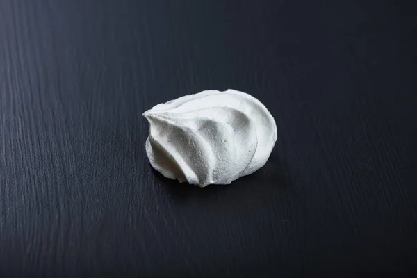 Único merengue fofo na mesa preta — Fotografia de Stock