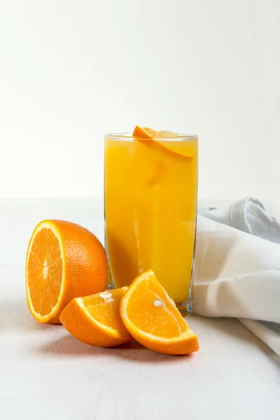 Glas apelsinjuice och orange bitar — Stockfoto