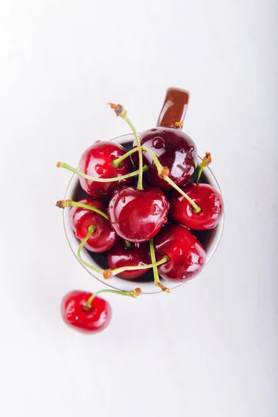 Saftiga färska körsbär i brun cup — Stockfoto