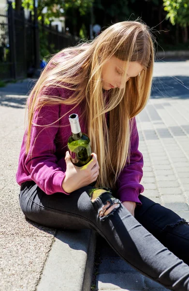 Dronken jonge vrouw met fles alcohol — Stockfoto