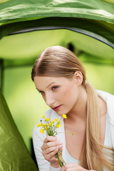 Jonge vrouw rustend in een tent op de natuur — Stockfoto