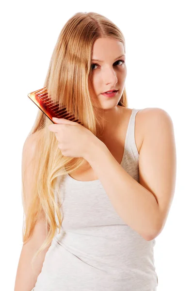 Giovane donna bionda spazzolando i capelli — Foto Stock