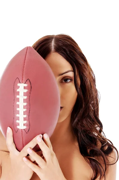 Beautiful nude woman holding american football ball. — Stock Photo, Image