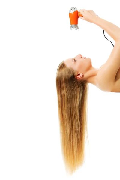 Молодая женщина сушит волосы, изолированные на белом — стоковое фото