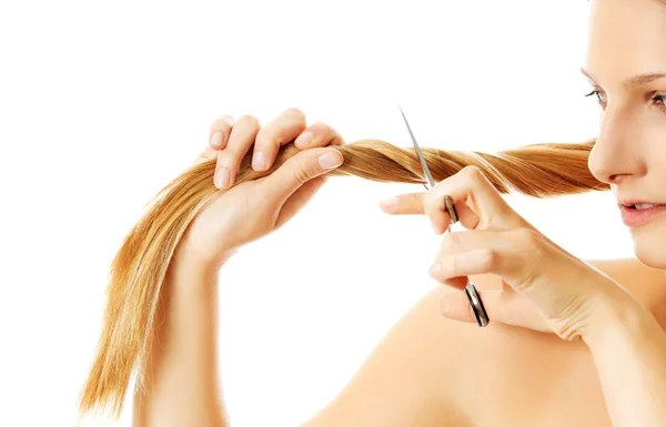 Attraente giovane donna sta tagliando i suoi lunghi capelli naturali — Foto Stock