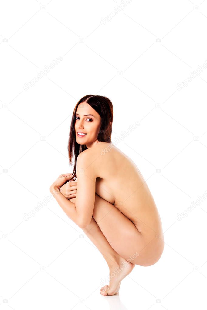 Nude woman squatting on the floor