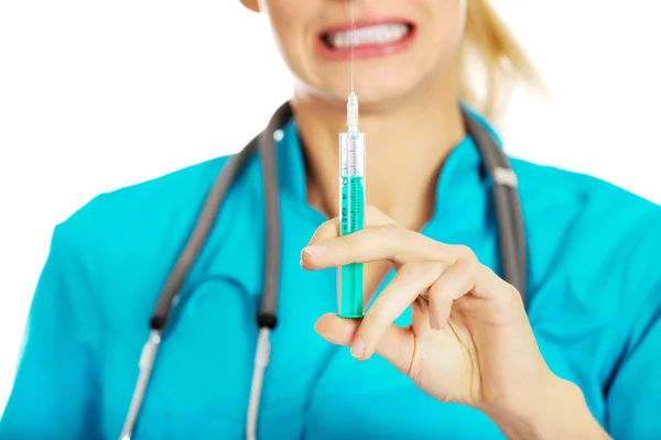 Female nurse or doctor with stethoscope holding syringe — Stock Photo, Image