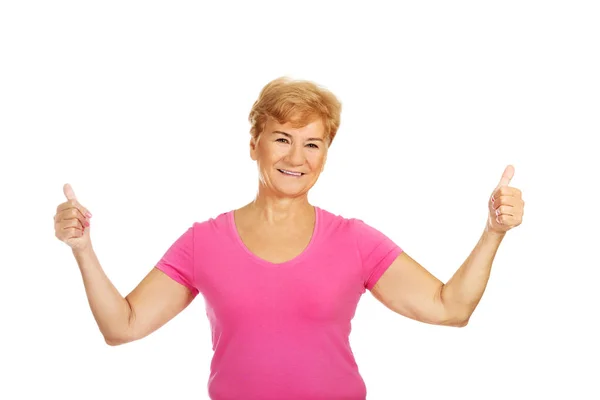 Gärna äldre kvinna visar tummen — Stockfoto