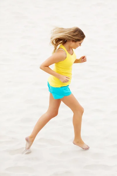 해변을 뛰어다니는 젊은 여자 — 스톡 사진